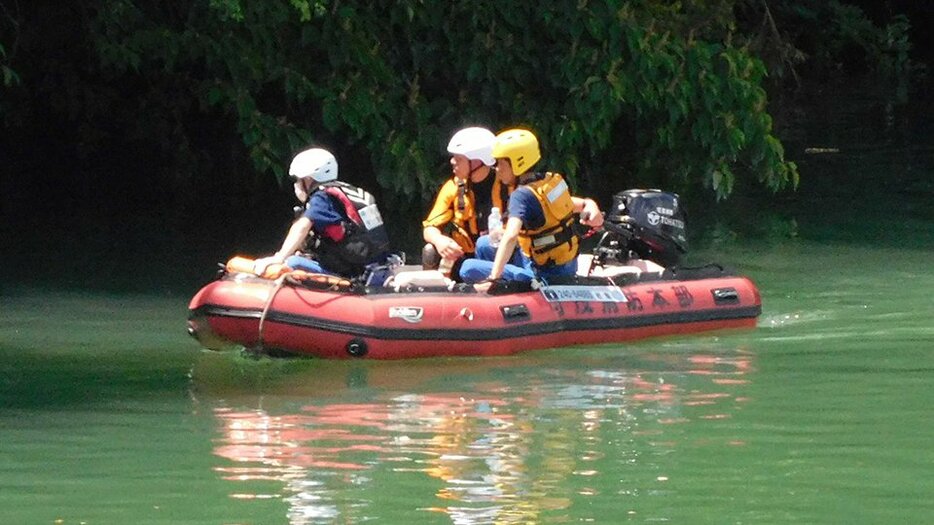 川に流された男女２人を捜索するボート＝２９日午後１時４５分、加茂郡川辺町石神、飛騨川