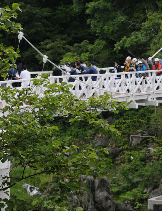 実況見分で神居大橋の上から被害者に見立てた人形を落とす道警の捜査員ら＝旭川市で２０２４年６月２５日午前１０時１５分、横田信行撮影