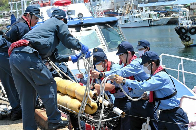 岸壁で要救助者などに見立てた浮きを警備艇から陸へ運び出す署員