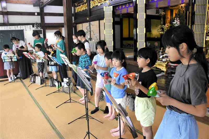 「国際芸術祭」に向けて、ハンドベルの演奏を練習する「光専寺土曜学校」の子どもたち＝8日、玉名市