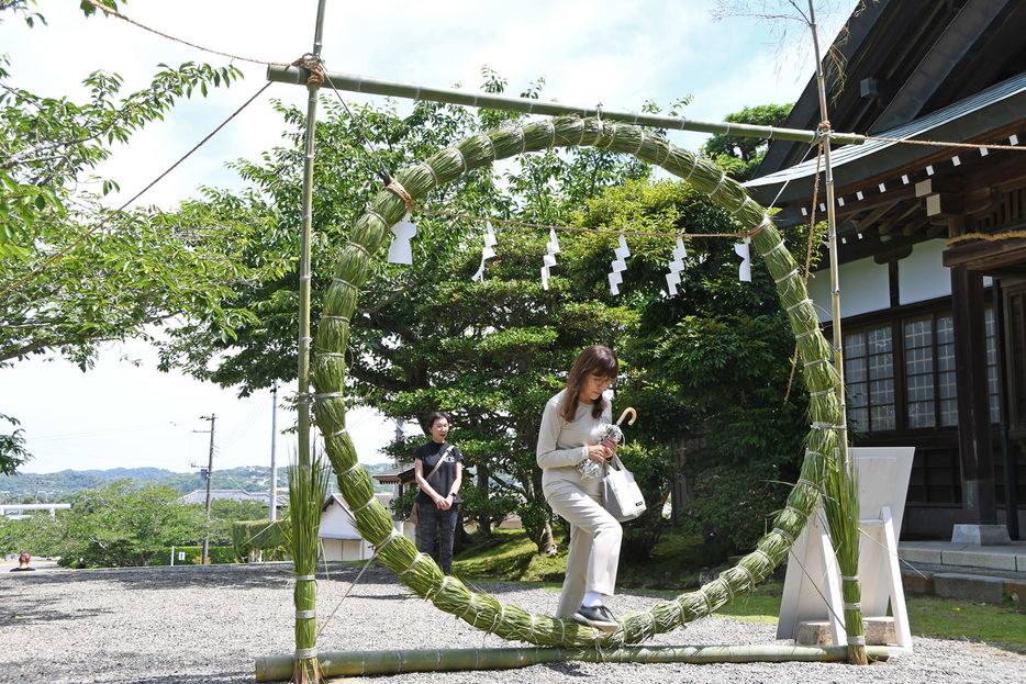 茅の輪をくぐる参拝客＝館山