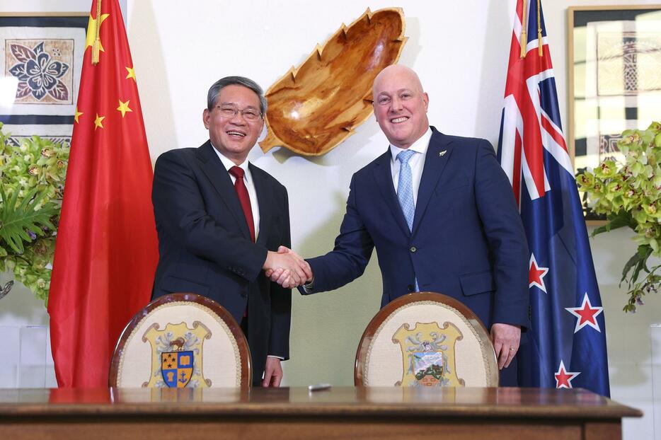 13日、ニュージーランドの首都ウェリントンで握手するラクソン首相（右）と中国の李強首相（ゲッティ＝共同）