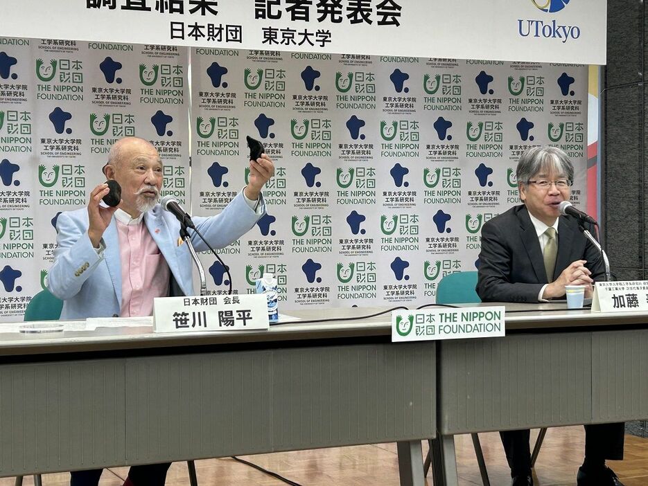 「マンガンノジュール」を手にする日本財団の笹川陽平会長（左）と東京大学大学院の加藤泰浩教授