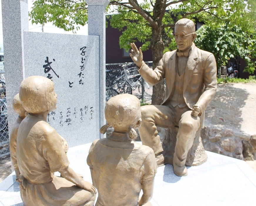 JR豊後森駅前に完成した銅像。久留島が子どもたちに童話を語り聞かせる姿を表現した＝玖珠町帆足