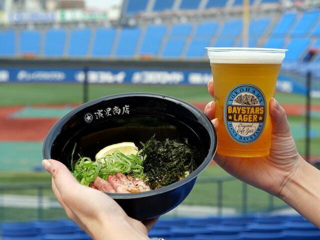 横浜DeNAベイスターズは、2024年6月27日より新フード「すたぁ麺」を横浜スタジアム内で発売。湯河原の大人気ラーメン店「らぁ麺 飯田商店」と共同開発した、素材にこだわった「まぜそば」です。