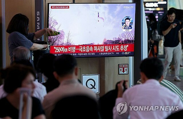 ソウル駅に設置されたテレビで北朝鮮の弾道ミサイル発射関連ニュースを見守る市民ら＝26日、ソウル（聯合ニュース）