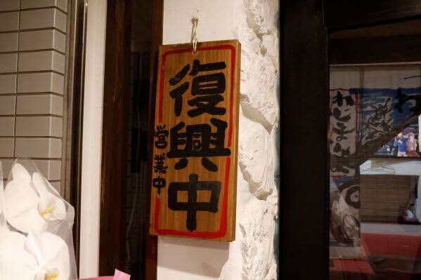 新たな店には「復興中」と書かれた札を掛け、客を迎える