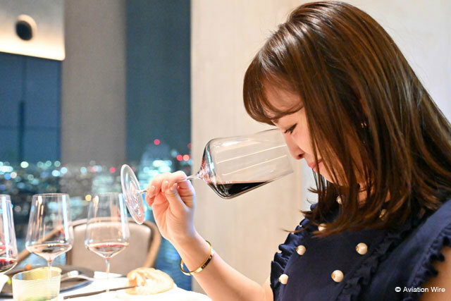 新宿のRestaurant Bellustarで開かれたJALとサントリーのメイカーズディナーでワインを楽しむ女性参加者＝24年6月 PHOTO: Tadayuki YOSHIKAWA/Aviation Wire