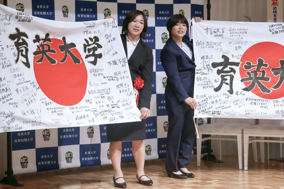 壮行会で寄せ書き入りの日の丸を贈呈された、レスリング女子の元木咲良（左）と桜井つぐみ＝15日、前橋市