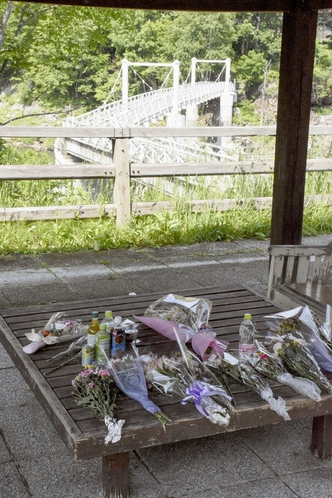 北海道留萌市の女子高生の殺害現場となった、旭川市の神居古潭地区にあるつり橋付近に手向けられた花束＝15日