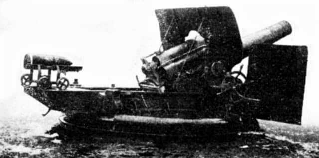 射撃姿勢の45式24cm榴弾砲。左側には装填用台車に載せられた重量約200kgの砲弾が見える。この砲弾の装填に際しては、砲手3名が力を合わせてランマーを使って砲尾へと押し込んだ。