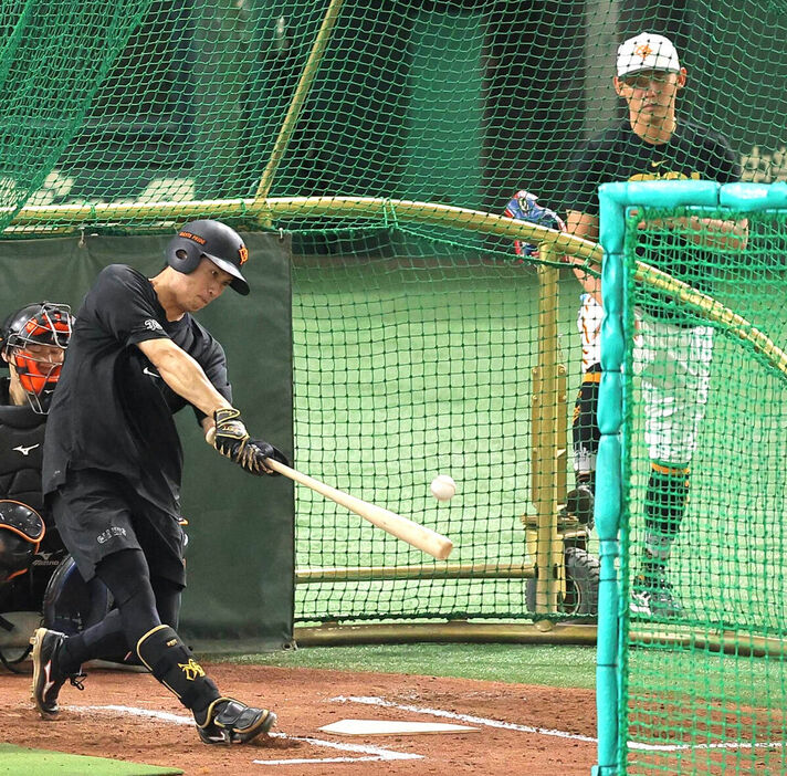 １９日、東京ドームで泉口の打撃練習を見守る矢野コーチ（右）