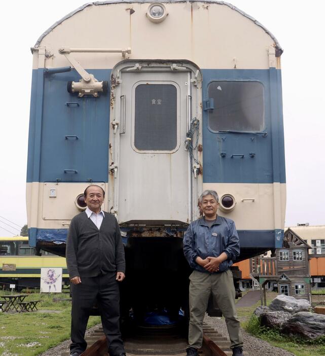 旧国鉄の食堂車「サシ581―31」の前で写真撮影に応じる村石愛二さん（左）と梅原健一さん＝2024年4月、千葉県いすみ市