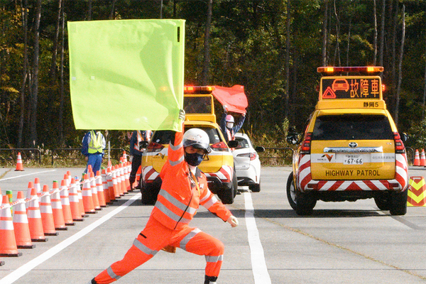 旗を振る交通管理隊員（画像：NEXCO中日本）。