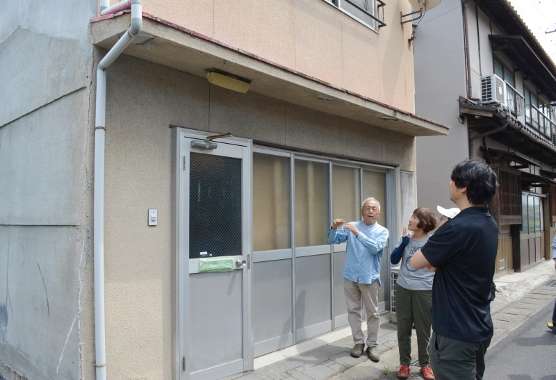 「旭坐」となる建物の前で改修計画を話すアートファームのメンバー