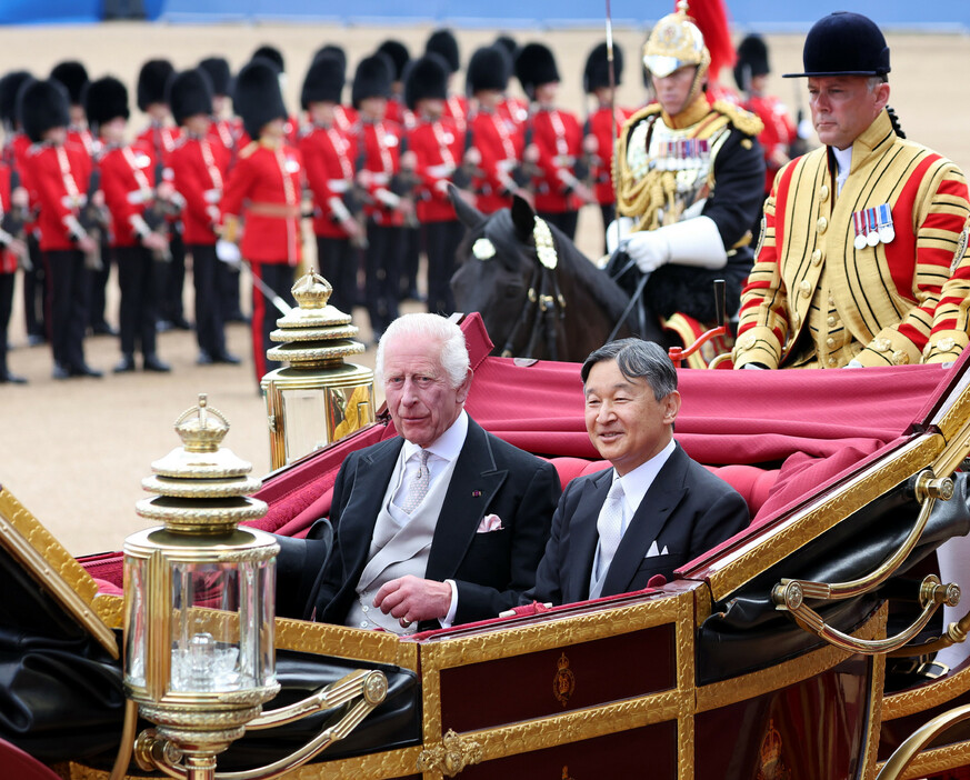英国訪問中の天皇、皇后両陛下は２５日、ロンドン中心部で国賓としての歓迎式典に臨まれた。写真は、バッキンガム宮殿に向けて馬車に乗られる天皇陛下と英国のチャールズ国王（代表撮影）