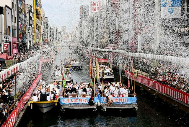 紙吹雪が舞う道頓堀川から歓声に応える歌舞伎俳優たち=2024年6月29日午後2時51分、大阪市中央区、伊藤進之介撮影