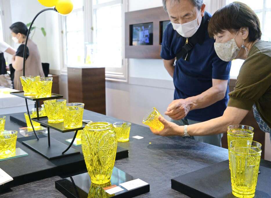 復元３５年を記念した黄色の薩摩切子に見入る来館者＝２２日、鹿児島市の磯工芸館