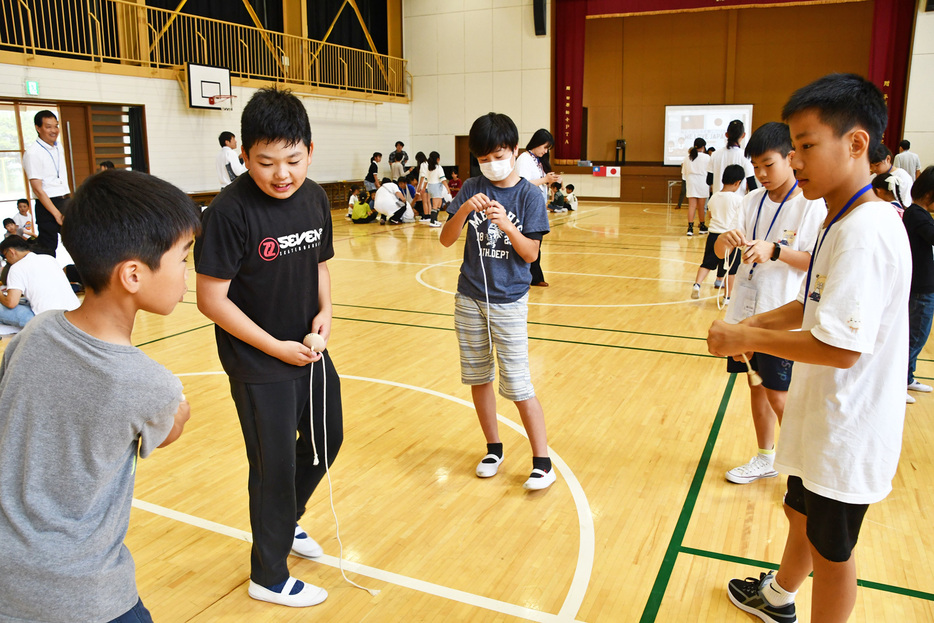 こま回しをして交流する児童ら＝鴨川