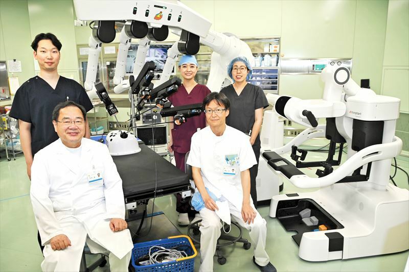 手術支援ロボット「ヒノトリ」と熊谷医師（前列右）のチームのメンバー