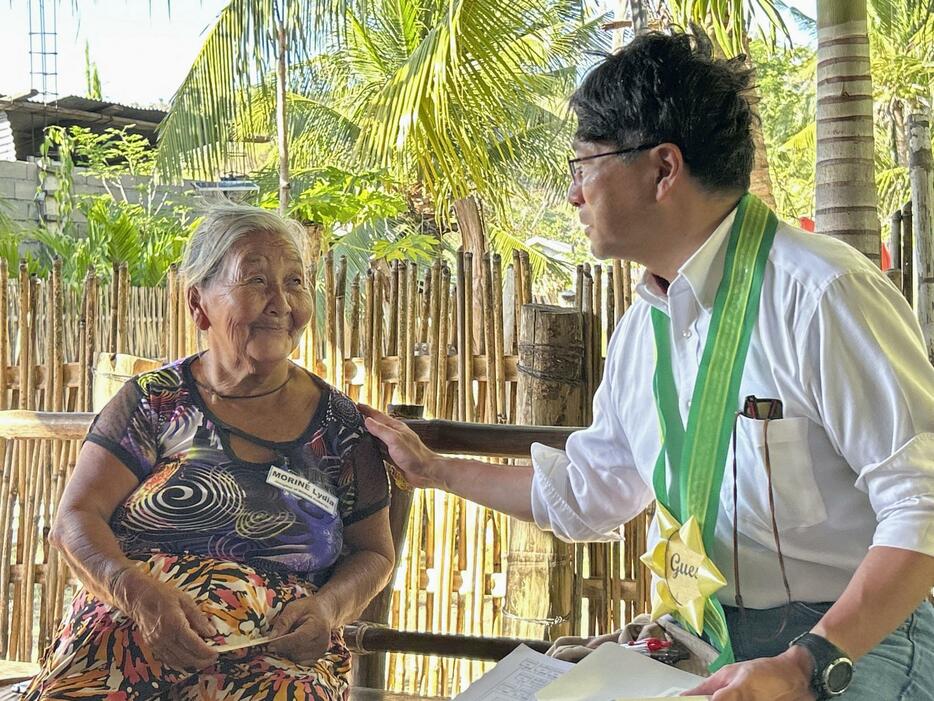 2024年5月、フィリピンのリナパカン島で、日系2世の80代女性（左）と面接する花田貴裕総領事（共同）