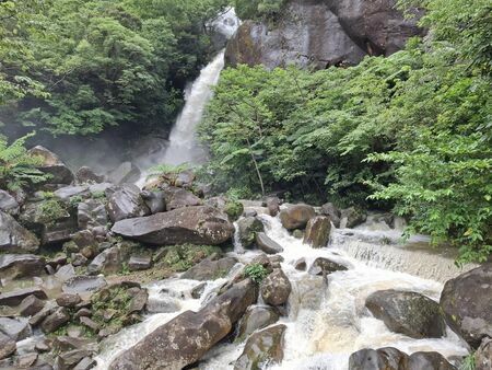 滝壺の下流の大きな岩も飲み込むように流れている轟の滝の水量＝１５日、名護市数久田の轟の滝