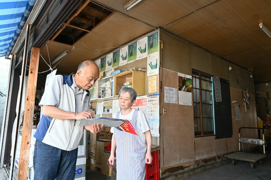 耐震診断の説明をする矢田部広志さん（左）。店舗兼住宅の母屋は旧耐震基準で建てられている＝6月中旬、下田市