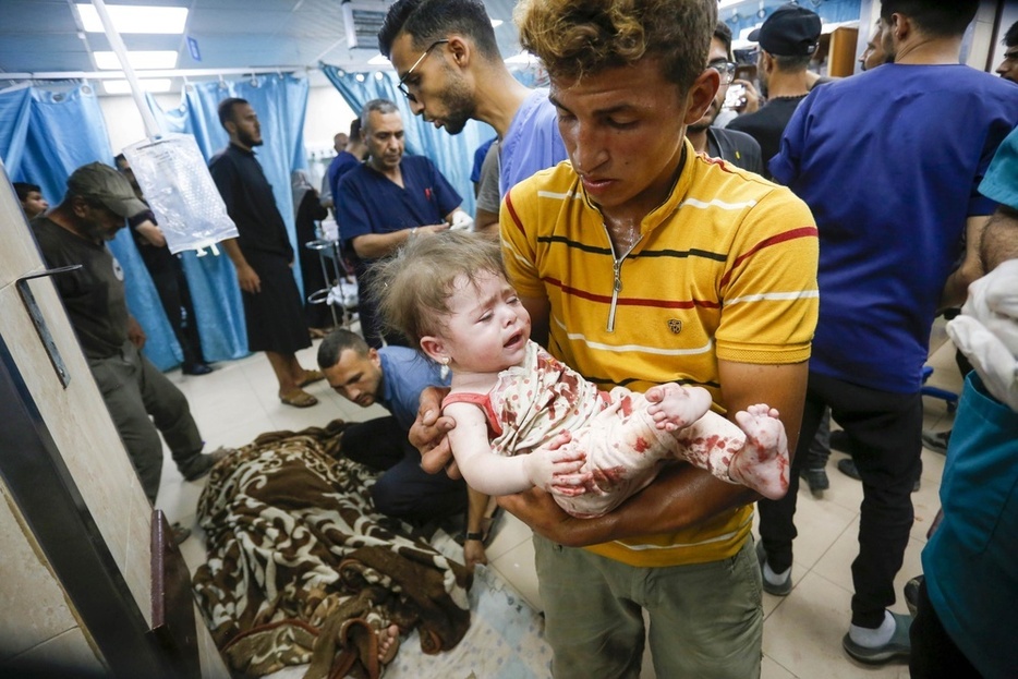 8日、ガザ中部デールバラハの病院に運ばれるパレスチナ人の子どもら（ゲッティ＝共同）