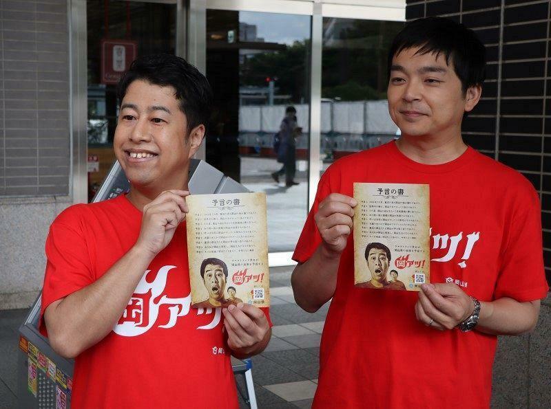 岡山県の2024年度の施策を伝える「予言の書」を持つ井口さん（左）と河本さん