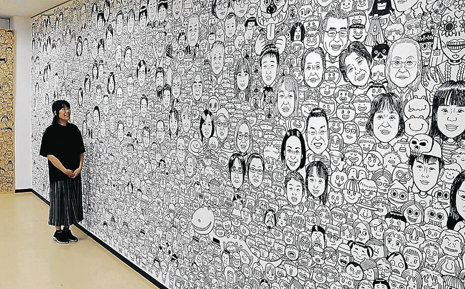 漫壁の似顔絵を仕上げた森さん＝南砺市の井波コミュニティプラザ「アスモ」