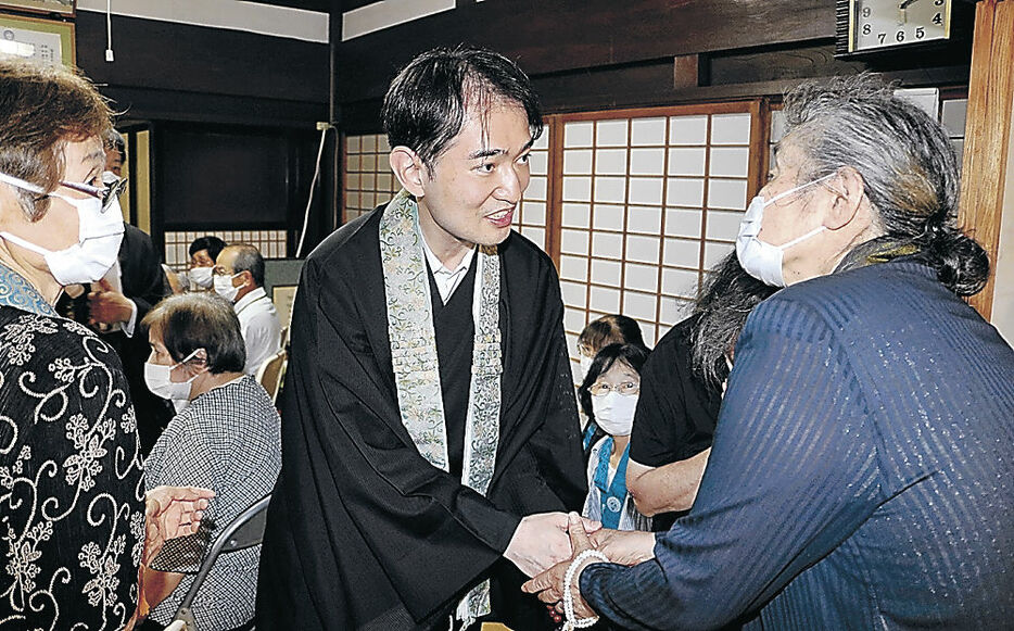 門徒一人一人握手を交わして声を掛ける大谷門主＝氷見市宇波の常尊寺