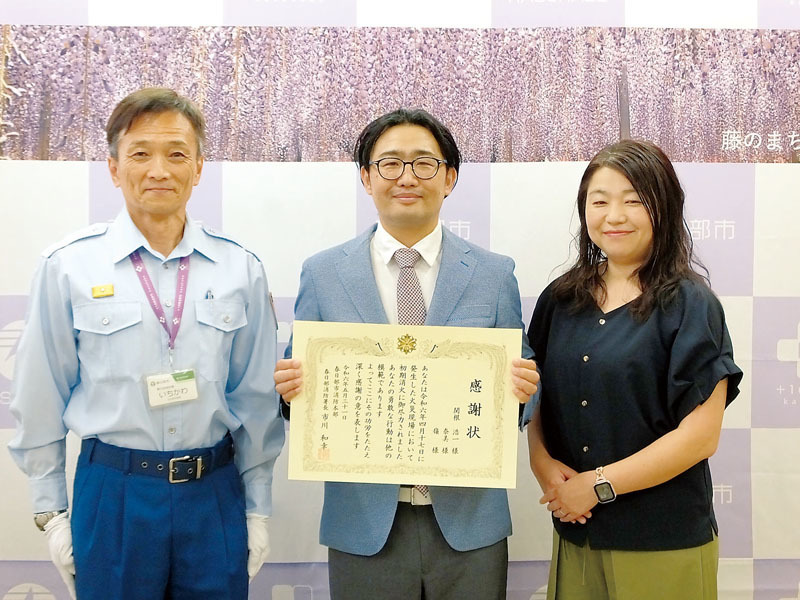 アパート火災の初期消火に貢献したとして感謝状を贈呈された関根浩一さん（中央）、妻の奈美さん（右）と、市川和幸署長＝5月31日午後、春日部消防署