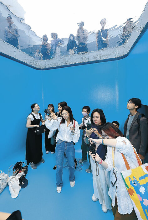 「スイミング・プール」の地下部で記念撮影などを楽しむ来館者＝２２日午前１０時半、金沢２１世紀美術館