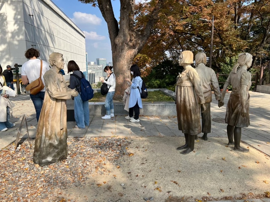 南山にある「平和の少女像」を見学する学生たち（2022年10月28日撮影）