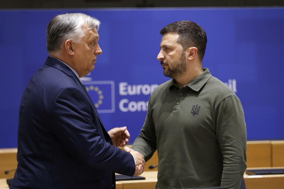 EU首脳会議の会期中、ウクライナのゼレンスキー大統領（右）と話すハンガリーのオルバン首相＝6月27日、ブリュッセル（AP＝共同）