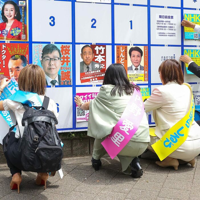 6月20日の告示日に選挙ポスターを張る都知事選候補者たち（写真・Pasya/アフロ）