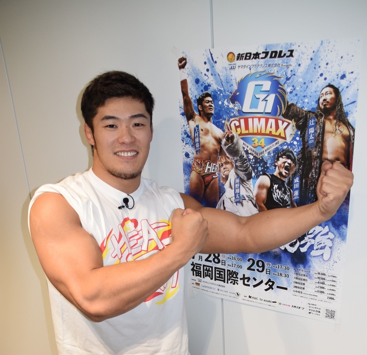 G1クライマックスのポスターの前でポーズする上村優也選手