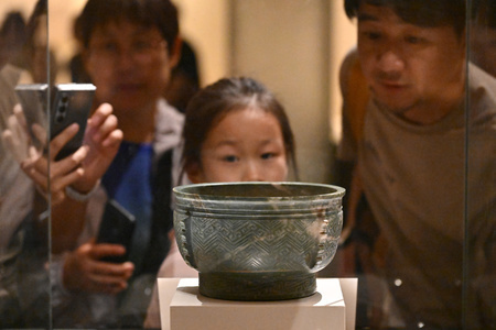 北京市の「中国国家博物館」で中国古代・商代の玉簋（ぎょくき、穀物を盛る容器）を見学する親子（2024年5月16日撮影、資料写真）