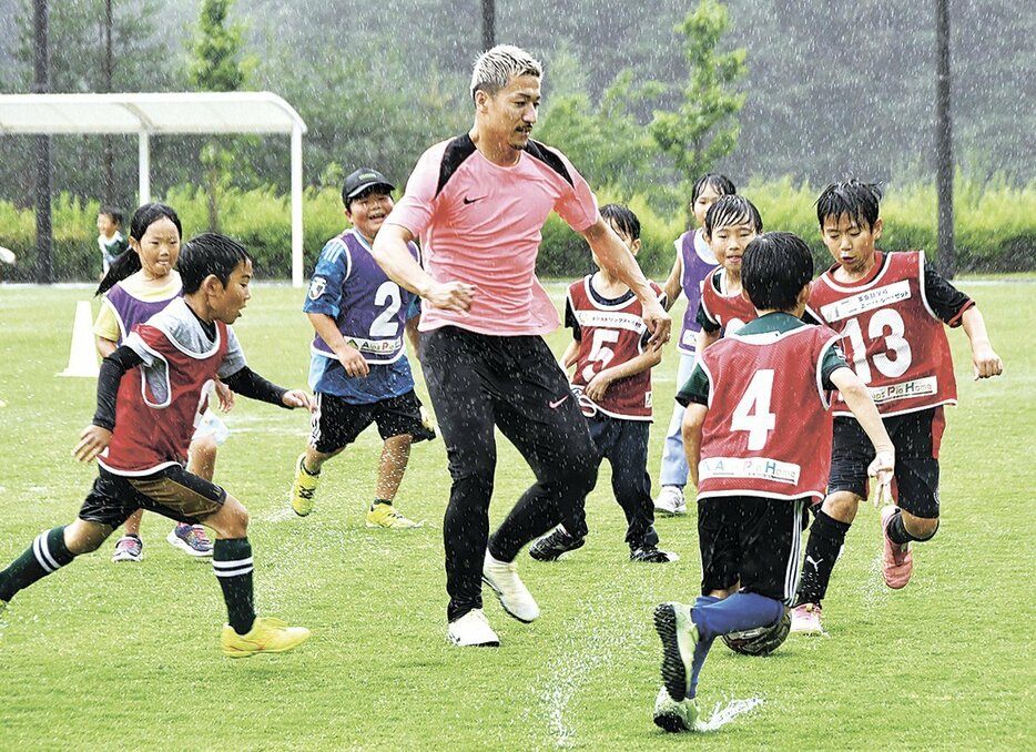 前田選手（中央）と一緒にプレーする小学生たち