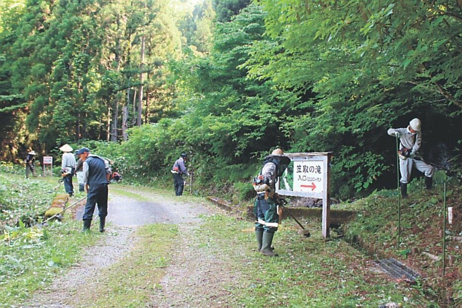 遊歩道周辺の草刈りに汗を流す住民