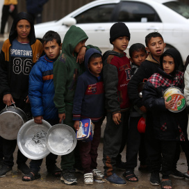 ハマスとイスラエル軍の戦闘が続く中、自宅を逃れ、難民キャンプの食糧支援の列に並ぶパレスチナ人の子供たち＝2024年2月2日、ガザ中部デイルアルバラ、ロイター