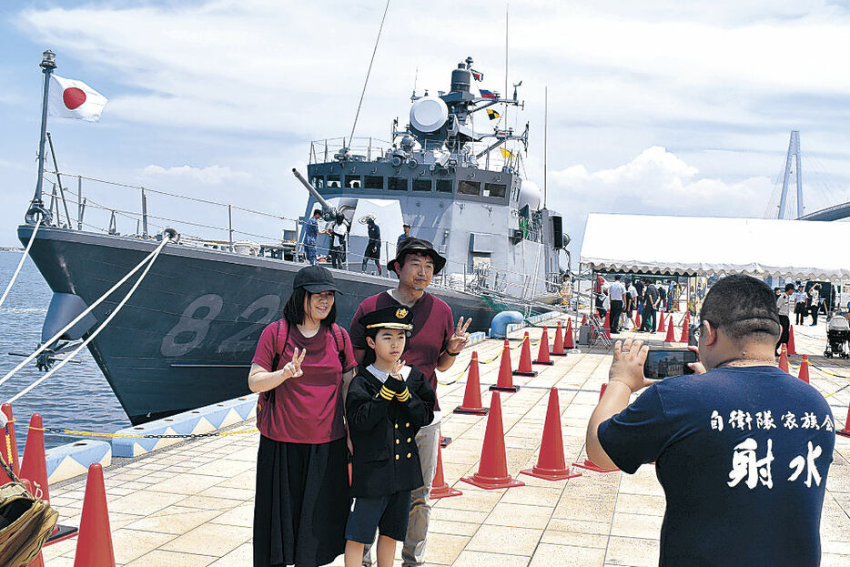 ミサイル艇の前で記念撮影する家族＝射水市の海王岸壁