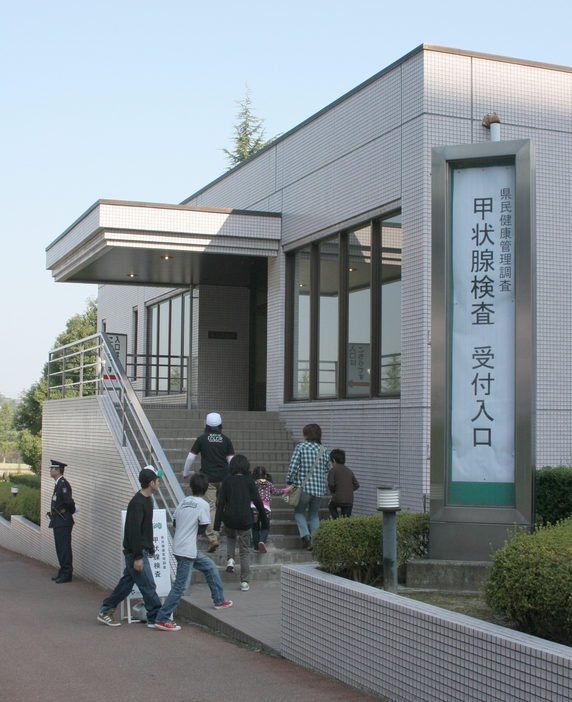 甲状腺検査の会場に向かう人々（福島市、2011年10月9日撮影、時事通信）