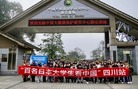 「中国ジャイアントパンダ保護研究センター雅安碧峰峡基地」入り口での「日本の大学生訪中団」と主催者側との合同記念撮影（2024年3月10日撮影、資料写真）。