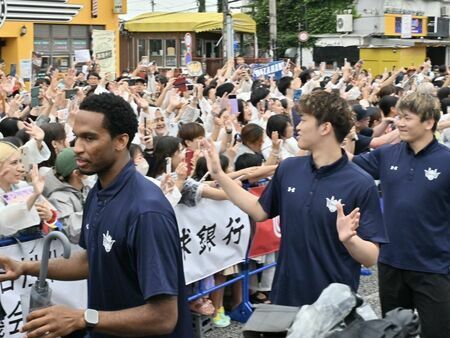 報告会に集まったブースターに手を振るキングスの選手ら＝１日、沖縄市のゲート通り（竹尾智勇撮影）