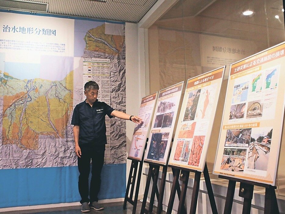 地震による土砂災害をテーマにしたパネル（右）と液状化リスクの高い場所を示す巨大地図（奥）＝立山カルデラ砂防博物館