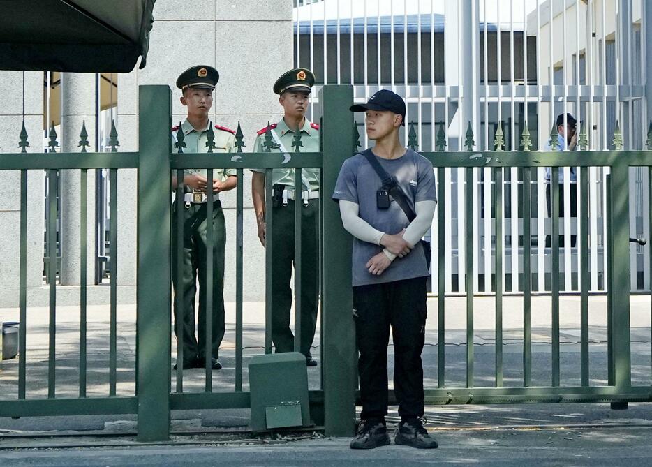北京の日本大使館前で警戒する治安当局者ら＝25日（共同）