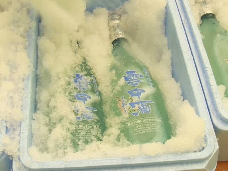 天然雪とともに箱詰めされた雪中酒＝２６日午前、飛騨市河合町