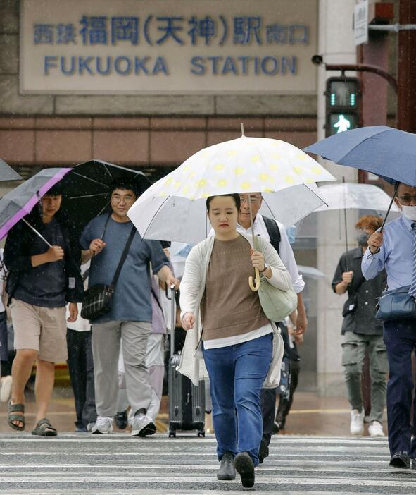 雨が降る福岡市内で、傘を差して歩く人たち＝27日午後