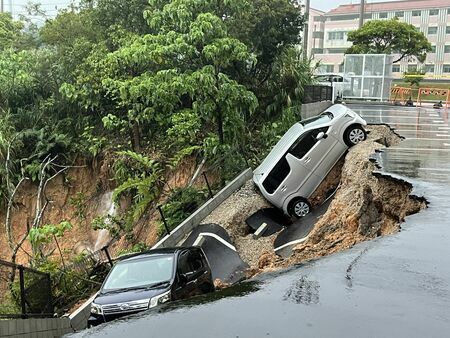 アパート駐車場の一部が崩れ、車2台が巻き込まれた土砂崩れ現場＝１２日、名護市為又